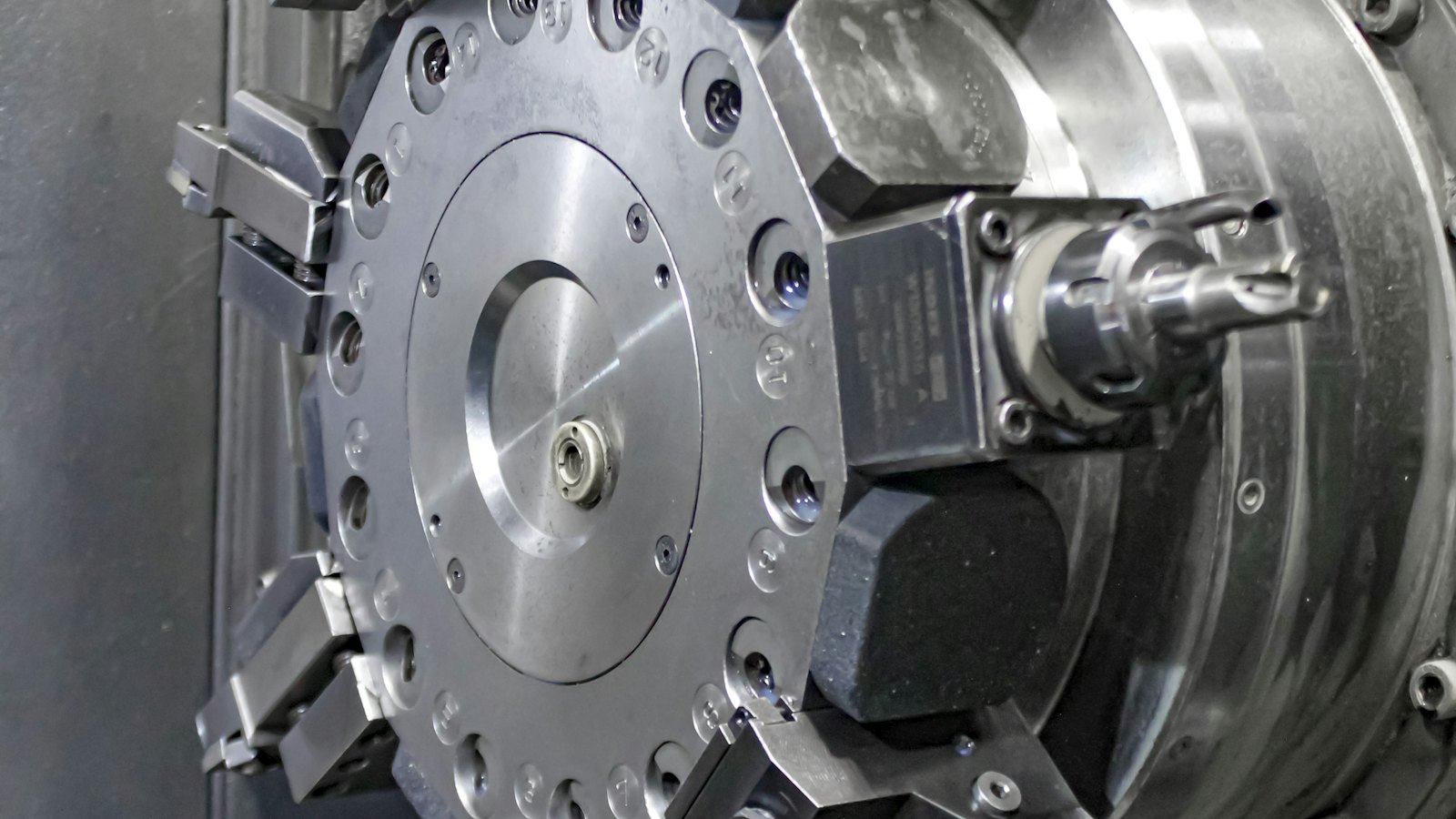Wide view of a CNC machine's circular tool turret holding multiple cutting tools